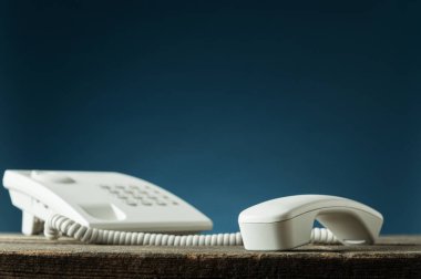 Telefonun açık olduğu beyaz sabit hat telefonu.
