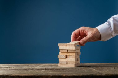 Bir iş adamının eli ahşap kazıklar yapıyor.