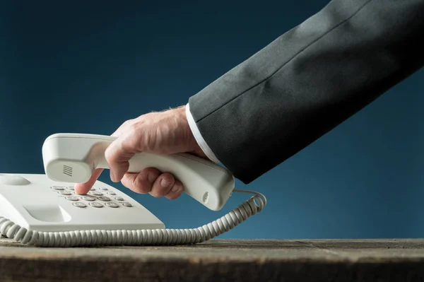 Hand of a businessman holding telephone handset dialing phone nu — Stock Photo, Image