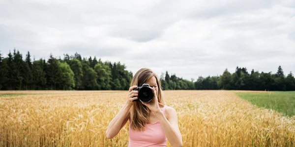 Fotógrafa do sexo feminino tirando fotos na câmera — Fotografia de Stock