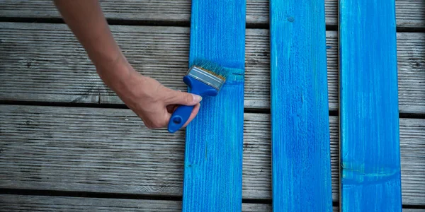 Female hand painting wooden planks — Stock Photo, Image