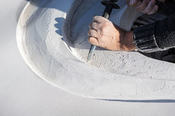 Beyaz bir taşın içine kıvrımlar oyan bir sanatçının yakın çekimi — Stok fotoğraf