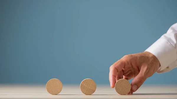 Placing thre blank wooden cut circles in a row — Stock Photo, Image