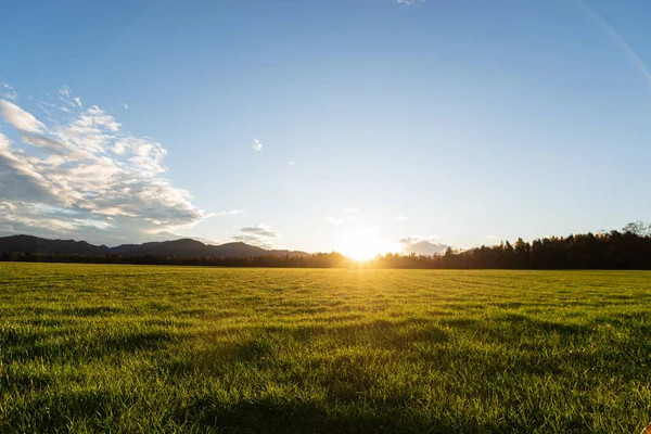 Hermosa Pradera Verde Con Sol Poniéndose Distancia Detrás Pequeñas Colinas — Foto de Stock