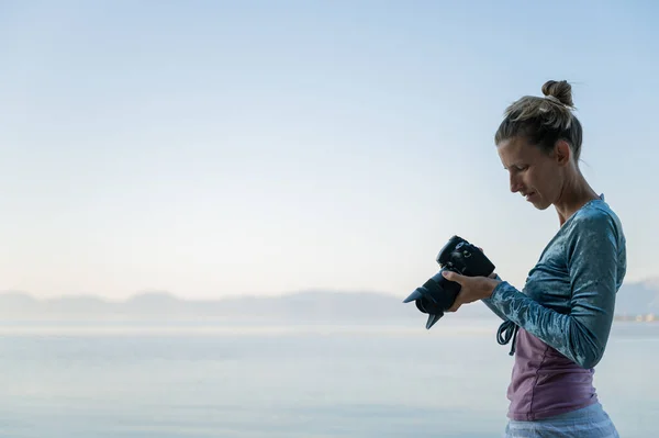 Young Female Photographer Standing Beautiful Calm Morning Sea Checking Photos — Stock Photo, Image