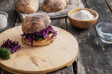 Tahtada bol sebzeli ve ekşi ekmekli zengin ve lezzetli vejetaryen burger..