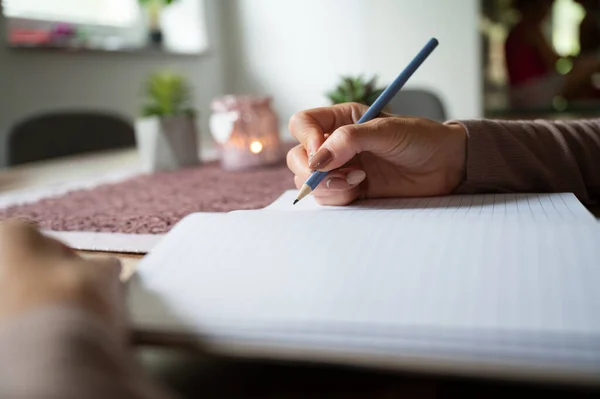 Low Angle View Woman Writing Blank Notebook Wooden Desk Candle — Stock Photo, Image