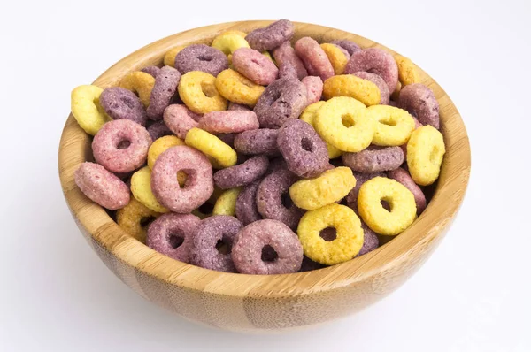 wooden bowl full of cereals in the form of colored circles