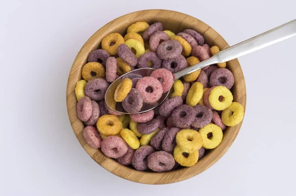 wooden bowl full of cereals in the form of colored circles