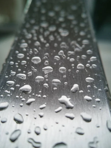 Small water drops on gray steel barrier