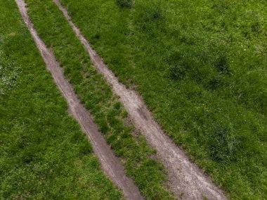 Çimlerle dolu yeşil düzlükler arasında çift yol