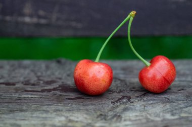 Taze iki tatlı Kiraz ahşap Bank arka plan üzerinde. taze olgun kiraz. arka plan açık havada 2 kiraz