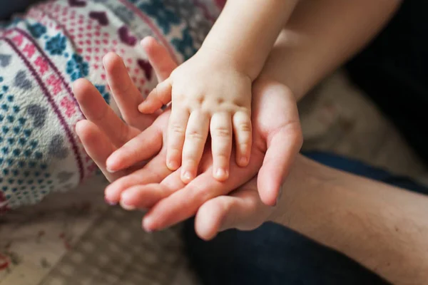Concepto familiar.Tres manos de la familia: bebé, madre y padre. Unidad, protección y felicidad. Enfoque en el asa infantil — Foto de Stock