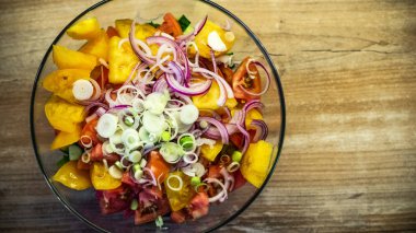 Taze ahşap arka plan üzerinde kase karışık yeşillik salatası