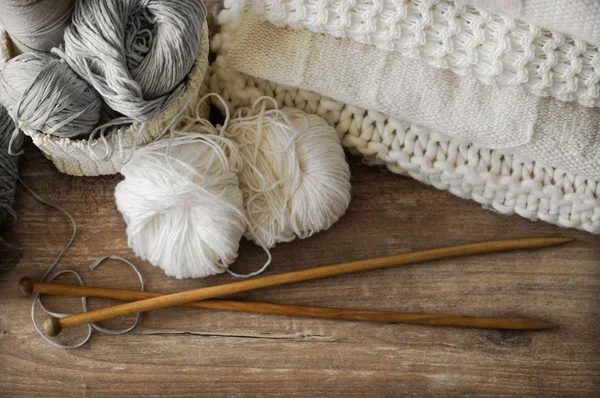 En vävd korg med vita och grå tråd för stickning och stickning nålar. Vita tröjor och garn för stickning närbild. Vinter — Stockfoto