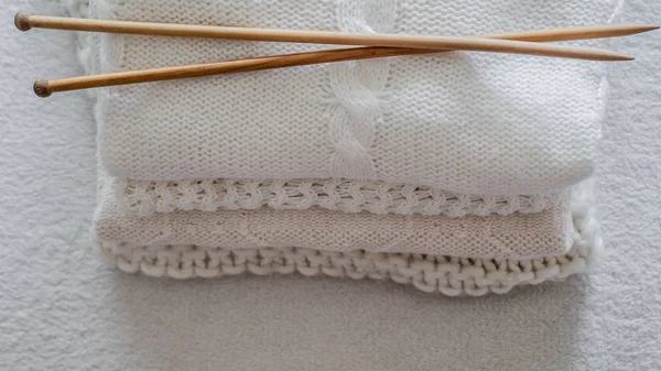 White sweaters and yarn for knitting close up. Knitting needles. Concept Handicraft. Place for text — Stock Photo, Image