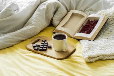 Sonbahar natürmort bahar. Yatakta kahvaltı. Beyaz yatak odası. Güzel evim. Kitaplar, çiçekler, çikolata ve kahve Kupası. düz lay