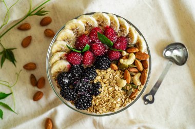 Sağlıklı kahvaltı kase yemek. Meyve sağlıklı bir yemek ile bir tabak içinde. Ahududu, muz, fındık. Diyet, Vejetaryen gıda kavramı 