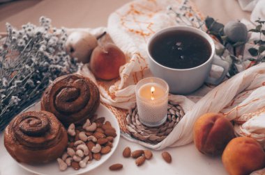 Bir tepsi çay, kruvasan, meyve, çiçek yatakta kahvaltı. Sabah. Rahat daire. Romantizm. parlak arka plan düzen. bir gün izin