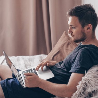 Yeni bir blog yazısı yazmak. Teknoloji, ana sayfa - yaşam tarzı kavramı yakından dizüstü bilgisayar ile çalışma ve yatağa evde oturan adamın