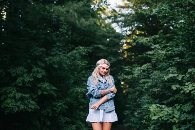 Romantik kız açık havada. Uzun saçlı. Mavi elbiseli kız yaz aylarında gün batımında bir alanda bir baş ağrısı ile. Gündelik yaz kıyafetleri.