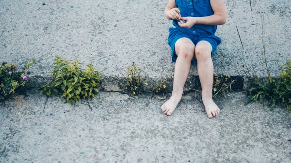 Bedårande liten flicka skratta på natur - glad tjej i en blå klänning och slagen av knäna sitter på trappan. Lycklig barndom — Stockfoto