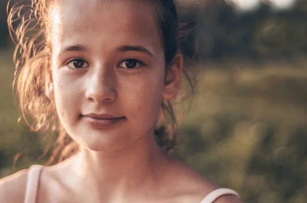自然の中夕方の日差しの中の非常に美しい若い女の子の肖像画。夏と牧草地で日当たりの良い天気を楽しむ女の子 — ストック写真