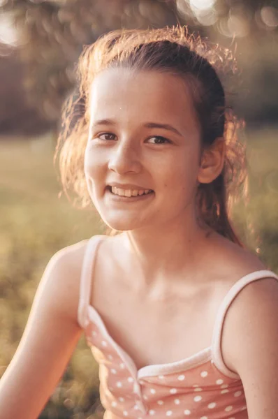Portret van vrij mooi jong meisje in de avondzon in de natuur. meisje geniet van de zomer en het zonnige weer op de weide — Stockfoto