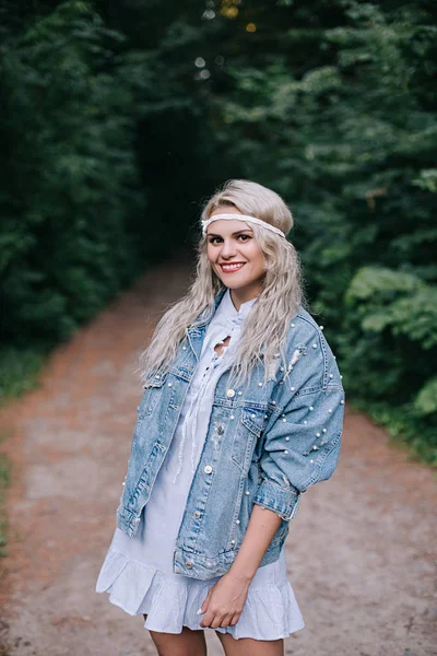 Chica romántica al aire libre. Cabello largo. Chica en un vestido azul con un dolor de cabeza en un campo al atardecer en verano. Ropa de verano casual . — Foto de Stock