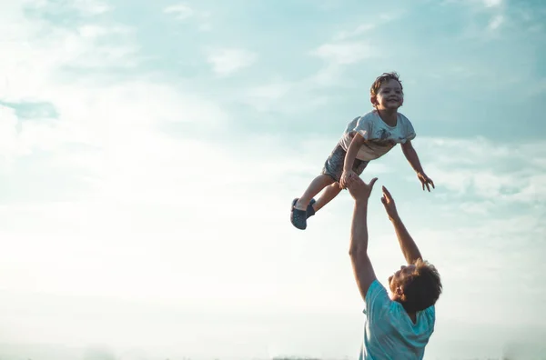 stock image Father throws up his cute and little son in the fresh air. Father's Day, Father and his son baby boy playing and hugging outdoors.