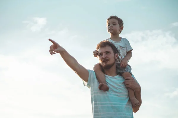 Mutlu çocuk babamla oynuyor. Babam ve oğlum dışarıda. Babası çocuğu sırtında taşıyor. Yaz tarlasında mutlu aile — Stok fotoğraf