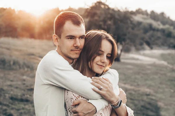 Jeune couple amoureux en plein air. Ils se sourient et se regardent. soleil du soir, câlins et bisous, style vintage — Photo