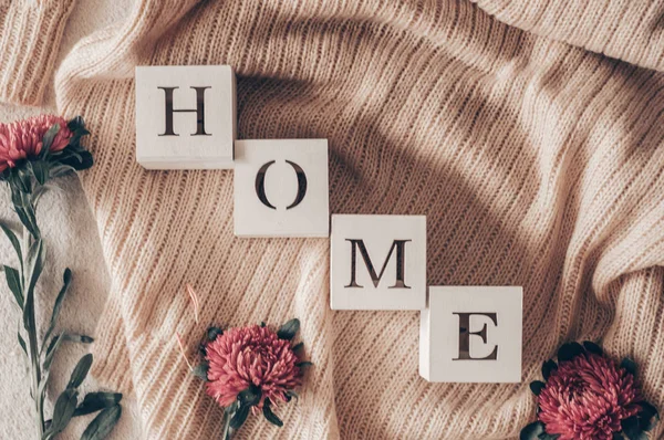 Hintergrund mit warmen Pullovern und der Aufschrift "Heimat". Stapel Stricksachen mit Herbstblumen, Herbstfrühlingskonzept — Stockfoto