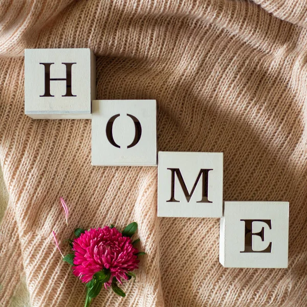 Hintergrund mit warmen Pullovern und der Aufschrift "Heimat". Stapel Stricksachen mit Herbstblumen, Herbstfrühlingskonzept — Stockfoto