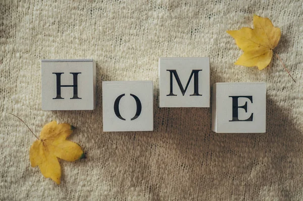 Hintergrund mit warmen Pullovern und der Aufschrift "Heimat". Stapel Stricksachen mit Herbstblättern, Strickwaren, Herbstkonzept. — Stockfoto