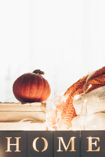 Background with warm sweaters and the inscription HOME. Pile of knitted clothes with leaves, pumpkins. Coziness. Autumn concept — Stok fotoğraf