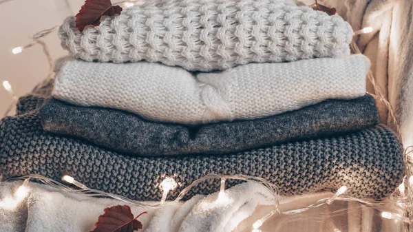 Plastik şeffaf sandalye - sıcak kazak. Sıcak arka plan, kazak, triko, sonbahar kış konsepti örme elbise yığını