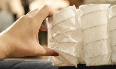 Cep bağımsız bahar profesyonel mobilya Uluslararası fuarında. Bir kadın elinde yatak malzemesi. 