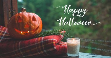 Background Halloween pumpkin on a cozy window sill with a red plaid. Whole pumpkin and sparkler outdoors. Happy Halloween! Autumn clipart
