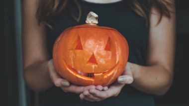 Cadılar Bayramı Balkabağı Bengal ışıkları ile bir kızın elinde. Tatil Halloween kavramı. Güzel bir kadınla kabaklar.