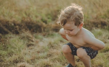Mutlu çocuk, küçük çocuk oyun, dalgın bakmak ve elinde sopa açık havada tutan. Metin için yer. Retro tonda. Yaz