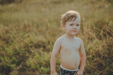 Mutlu çocuk, küçük çocuk oyun, dalgın bakmak ve elinde sopa açık havada tutan. Metin için yer. Retro tonda. Yaz