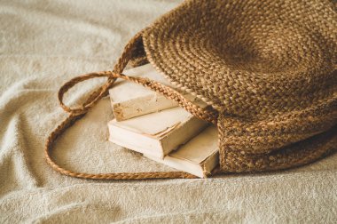 Eski kitaplar ve vintage hasır çanta üzerinde beyaz sıcak battaniye. Çanta kadın saman yaz. Kahverengi el yapımı doğa çanta