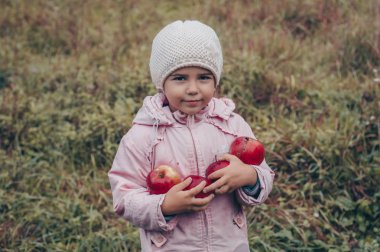 Kırmızı elma onun elinde tutan mutlu bir çocuk. Komik çocuk sonbahar Park'ta açık havada hasat