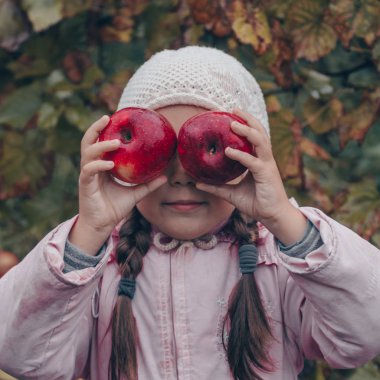 Kırmızı elma onun elinde tutan mutlu bir çocuk. Komik çocuk sonbahar Park'ta açık havada hasat
