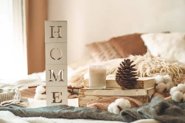 Ainda detalhes da vida em casa interior da sala de estar e da inscrição HOME. Livros e xícara de chá com cone e algodão. Lê. Descanso — Fotografia de Stock