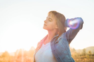 Sonbahar kız doğa alanında. Güzellik kız açık havada, Güneş ışınları elinde yükselterek. Güzel genç Model kız