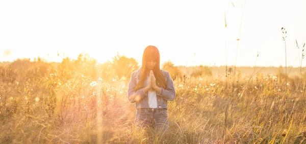 Gadis menutup matanya, berdoa di luar ruangan, Tangan terlipat dalam konsep doa untuk iman, spiritualitas dan agama. harapan, konsep mimpi . Stok Gambar