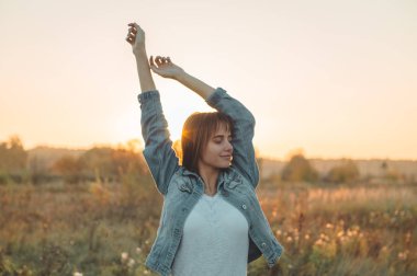 Sonbahar kız doğa alanında. Güzellik kız açık havada, Güneş ışınları elinde yükselterek. Güzel genç Model kız