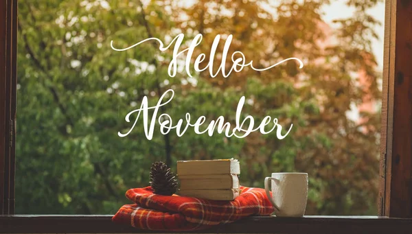 Привет Ноябрь. Уютный осенний натюрморт: чашка и открытая книга на винтажном подоконнике с красным одеялом, тыквой, свечами. Осень. Дождь — стоковое фото
